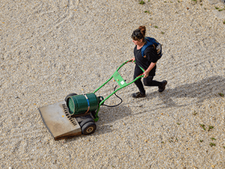 Agrandir l'image - fenêtre modale - Corinne Lescoutre pousse une machine dans le jardin.