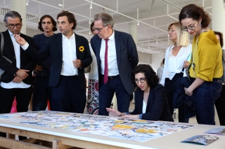 Agrandir l'image - fenêtre modale - La ministre de la Culture et la délégation regardent le plan de l'IMVT posé sur une table