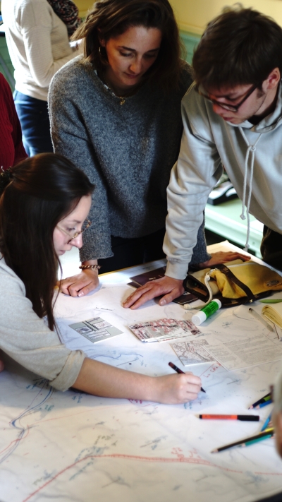 Agrandir l'image - fenêtre modale - Trois jeunes sont autour d'une carte paysagère